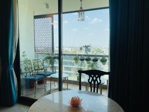 斋浦尔35 Sahakar Suites-A Luxury Aparthotel in Jaipur的配有大窗户的客房内的桌椅