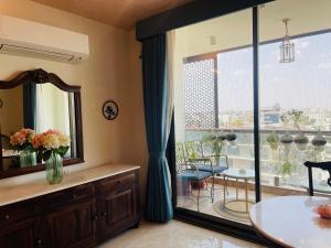 斋浦尔35 Sahakar Suites-A Luxury Aparthotel in Jaipur的浴室设有大窗户和鲜花桌