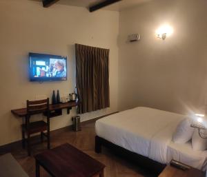 科代卡纳尔Mango Hill Kodai的酒店客房,配有床和电视