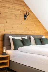 上陶恩Apartments Am Dorfplatzl的一间卧室设有一张带木墙的大床