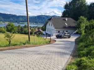 TrattenAparts Lakeview -Gerlitzen -Ossiacher See -Ski的停在白色房子前面的汽车