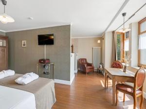 博尔赫隆Café René Borgloon的一间卧室配有一张床、一张桌子和一张沙发