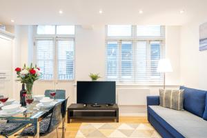 伦敦Turnmill Apartments的客厅配有蓝色的沙发和电视