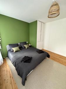 BaugéAppartement T3 cosy et moderne的一间卧室设有一张带绿色墙壁的大床