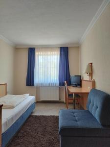 莫斯堡Gasthof zur Länd的酒店客房配有一张床和一张带电脑的书桌