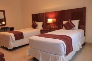 塞米亚克Argya Santi Suite and Villas的酒店客房,设有两张床和一盏灯