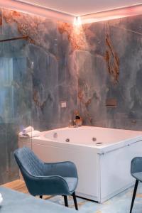 加利波利Suite Acquamarina Relais Stapane的一间带浴缸的浴室,前面设有两把椅子