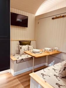 杜伦Bodos’ Shepards Hut的客房设有桌子、床和电视。