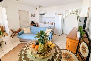 圣吉尔莱班Sunset Océan - appartement T2 avec vue imprenable sur l'océan et piscine的厨房里的桌子上放着一篮水果