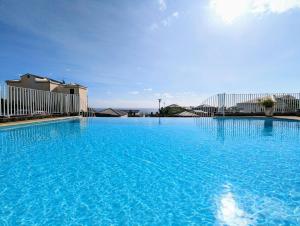 圣吉尔莱班Sunset Océan - appartement T2 avec vue imprenable sur l'océan et piscine的蓝色海水大型游泳池