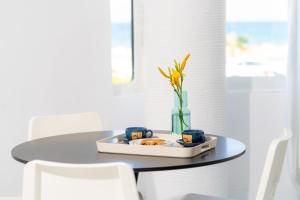 罗希姆诺SyntheSeas Residence的一张桌子,上面有一盘食物和花瓶