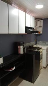 波哥大Cómoda y muy bien ubicada的厨房配有黑炉和白色橱柜。