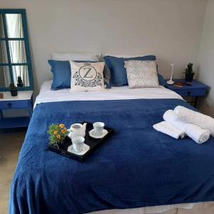 瓜拉雷马Chalézinho Santorini的蓝色的床,上面有盘子的食物