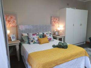 波罗瓜尼Tree Orchid的一间卧室配有一张带黄色毯子的大床