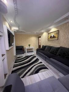 奇姆肯特15 Apartments的客厅配有黑色沙发和地毯。