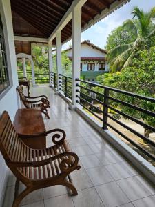 EttukalaGreen Village Negombo的一个带2张长椅的海景门廊