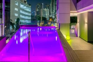 巴拿马城巴拿马雅乐轩酒店 的一座游泳池,在大楼里设有粉红色的灯光