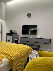As Sayl aş Şaghīrسكون الفاخرة - دخول ذاتي的卧室设有墙壁上的电视和黄色的床。