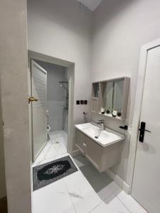 As Sayl aş Şaghīrسكون الفاخرة - دخول ذاتي的白色的浴室设有水槽和淋浴。