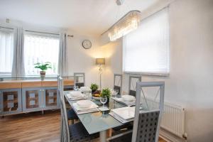 罗瑟勒姆Rawmarsh House, Rotherham for Contractors, Business & families -Monthly Discount的一间设有玻璃桌和椅子的用餐室