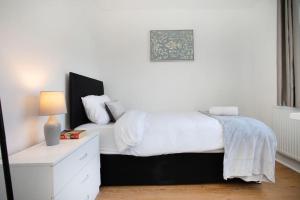 罗瑟勒姆Rawmarsh House, Rotherham for Contractors, Business & families -Monthly Discount的卧室配有白色的床和白色梳妆台