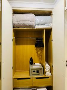 圣保罗Flat Congonhas的客房设有带微波炉和毛巾的衣柜。