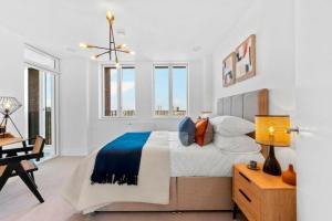 伦敦Luxurious two-bedroom flat with scenic views的卧室配有一张床、一张书桌和窗户。