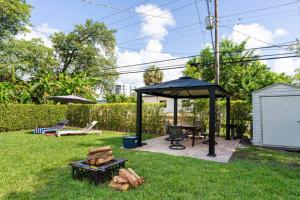 迈阿密Cozy Place的庭院中的凉亭,配有桌子和烧烤架