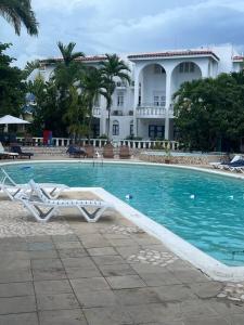 拉纳韦贝Beachfront Luxe Apt的房屋前设有一座带两把躺椅的游泳池