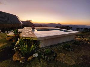 圣本图-杜萨普卡伊Cabana Alpes的一座游泳池,位于一座享有日落美景的房屋的顶部