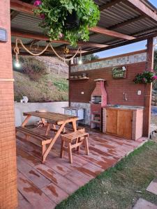 圣本图-杜萨普卡伊Cabana Alpes的庭院设有野餐桌和烧烤架。