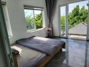 兴安Tranquil Retreat Lux Villa in HungYen Countryside的一张位于带大窗户的房间内的床铺