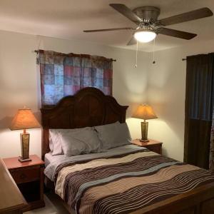 墨尔本Vacation home的一间卧室配有一张带两盏灯的床和吊扇。