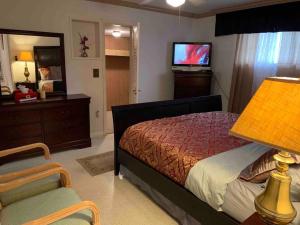 墨尔本Vacation home的一间卧室配有一张床、一台电视和一把椅子