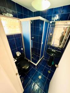 MacutoCasa de la Playa的蓝色瓷砖浴室设有黑色厕所和水槽