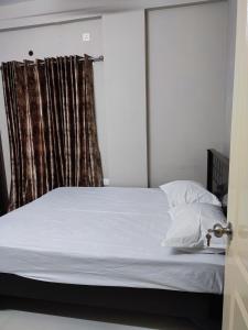 维沙卡帕特南Rahul's Castle Guest House的一间卧室配有一张带白色床单的床和一扇窗户。