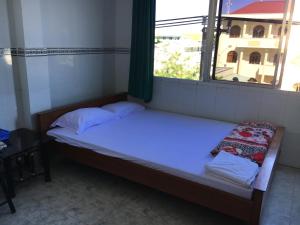 金瓯Khách sạn Thiên Phúc的窗户客房内的小床