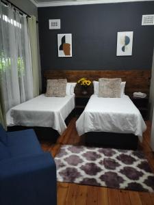 德班Inkanyezi guest house的一间设有两张床的房间和一张地毯
