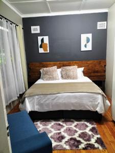 德班Inkanyezi guest house的一间卧室配有一张大床和一张蓝色的沙发