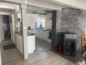 奥特罗特Appartments Rue Des Châteaux的厨房配有白色橱柜和砖墙