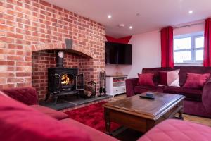 登比Cariad - Spacious 3 bed, group getaway Luxury Cottage with Private Hot Tub的一间设有砖墙和壁炉的客厅