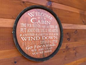 鸽子谷Fully Loaded Cabin In Heart Of Pigeon Forge的墙上的标志,欢迎客人光临小屋