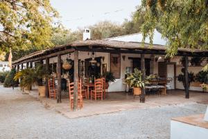 拉苏维亚LA CUADRA, Finca a los pies de Sierra Nevada, a 10 minutos del centro, Piscina, Jardín, Barbacoa的房屋设有带桌椅的庭院