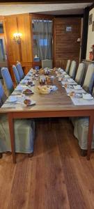 蒙热内夫尔瓦莱里酒店的一张带椅子的大木桌和一张带食物的长桌