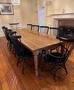 Pinetown Bridge Bnb LLC的一张带黑色椅子的木桌和壁炉