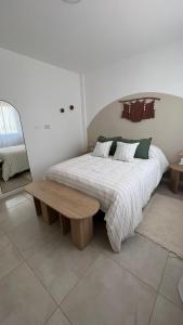 乌拉圭河畔康塞普西翁Departamento complejo Vita的一间卧室设有一张大床和一张木凳