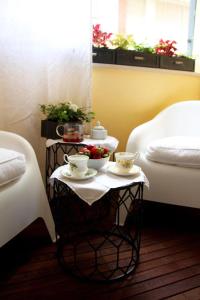 西维尔诺瓦·马尔凯Nest House & Relax的一张桌子,桌子上放着两张床,还有两杯和一碗鲜花