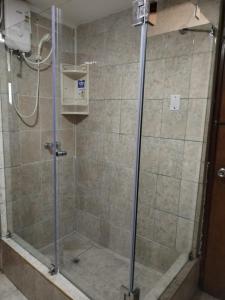 利马Hostal Turístico El Cajamarquez的浴室里设有玻璃门淋浴