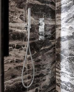 鹿特丹Le Marin Boutique Hotel的带淋浴的浴室(带石墙)
