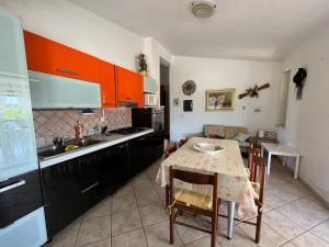 伊索拉迪卡波里祖托Villa Le Cannella的一间带桌子的厨房和一间带橙色橱柜的厨房
